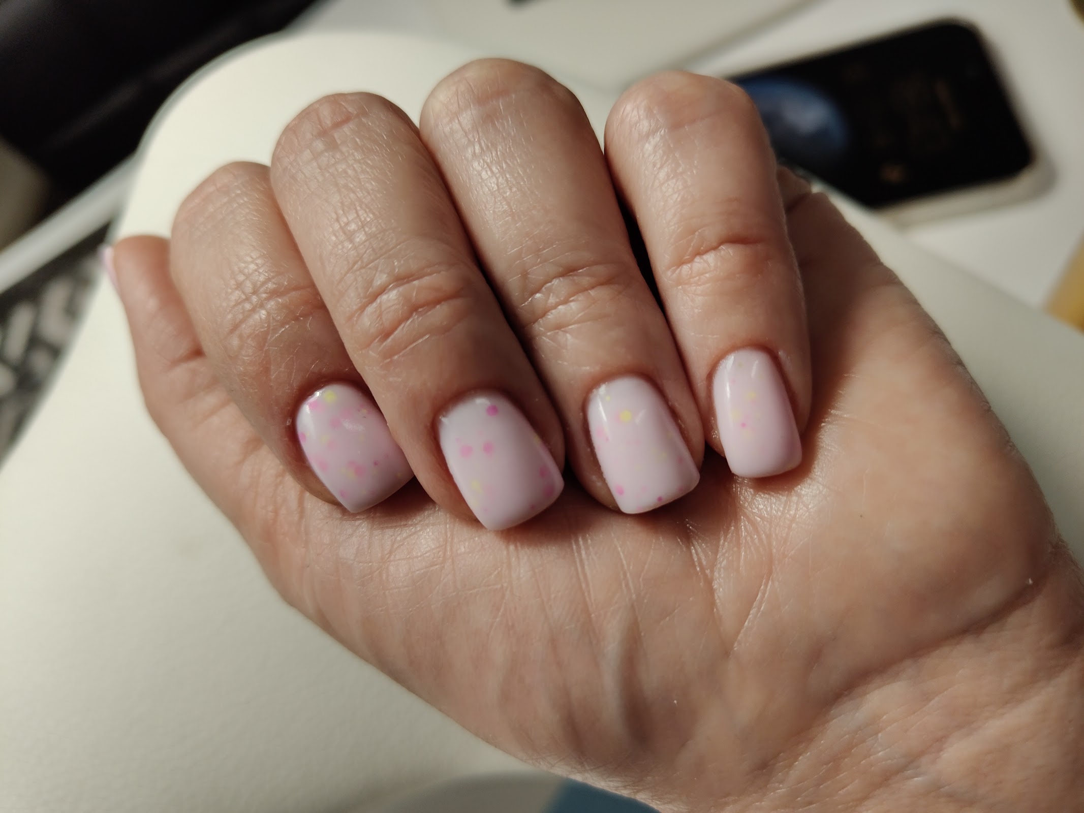 Delikatny manicure w odcieniu pudrowego różu z drobinkami